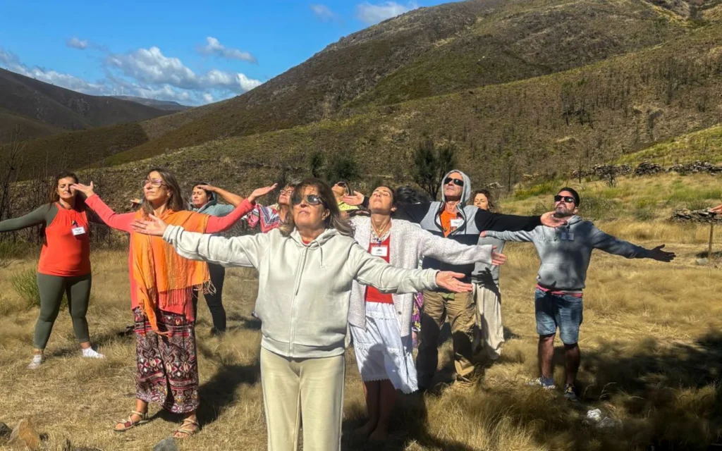 Participantes de braços abertos num retiro de inverno na Serra da Arada